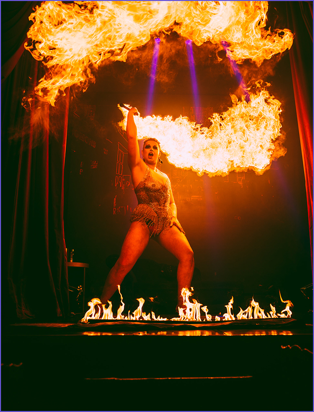 A fire performer is wielding a fire torch during a dinner show