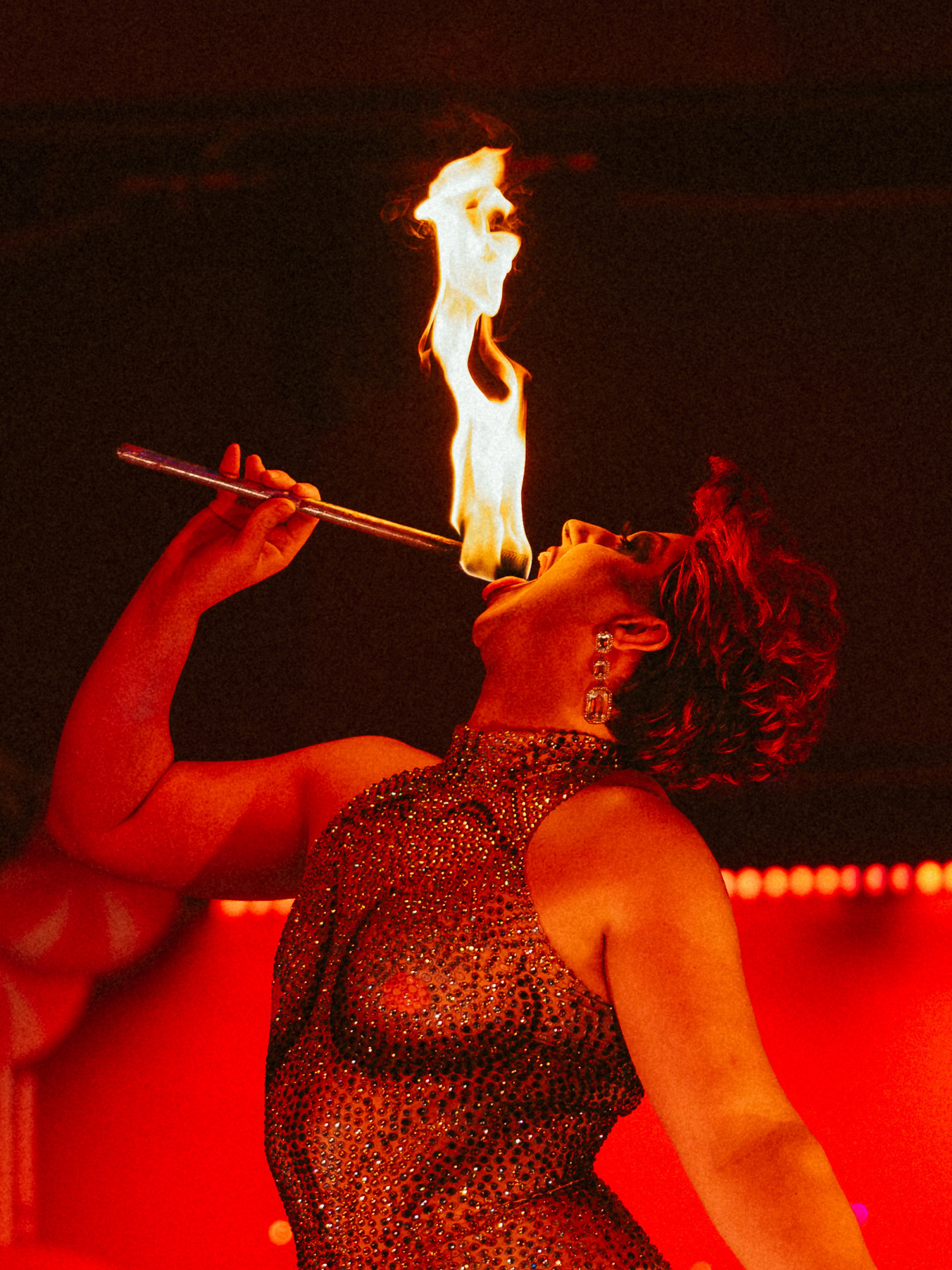 A performer posing with fire in their mouth during a cabaret and variety show
