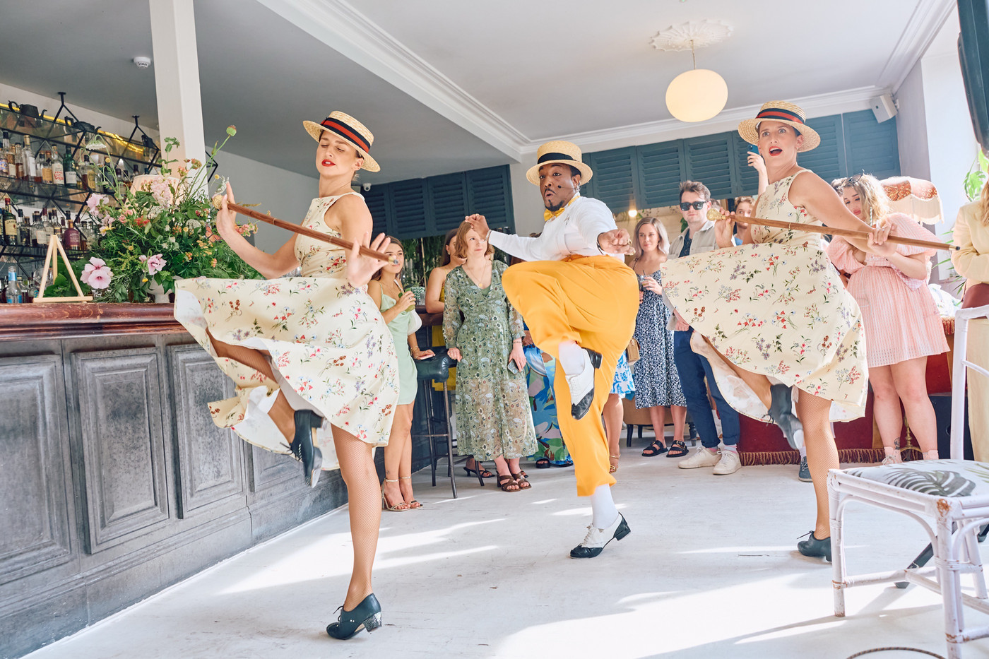 A singer surrounded by two dancers performing at a summer corporate party event