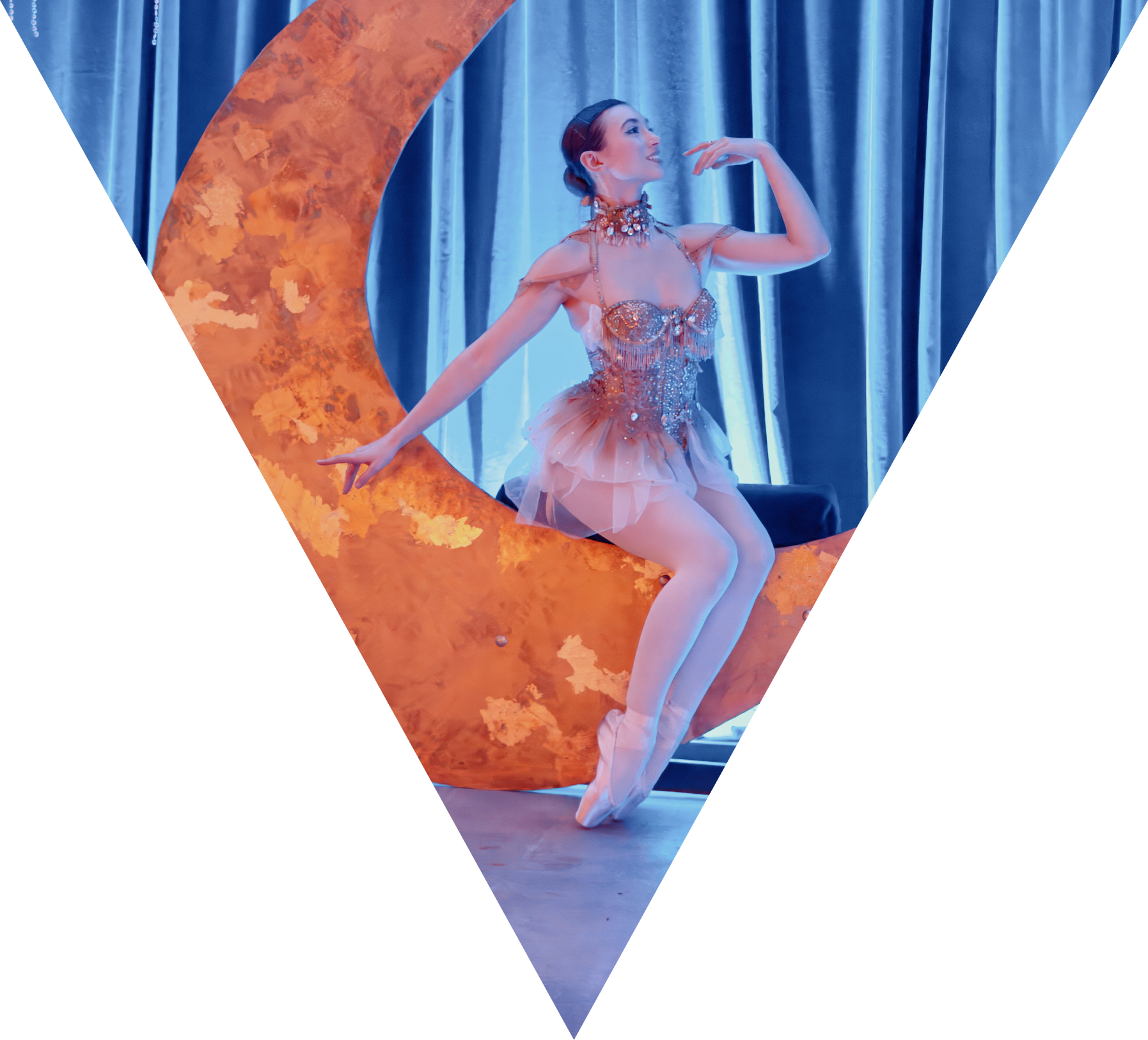 A ballet performer sitting on a crescent moon performing at a corporate brand event